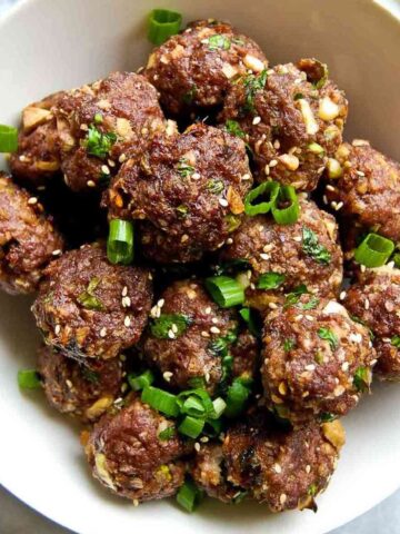 Closeup of Firecracker Meatballs with scallions in bowl.
